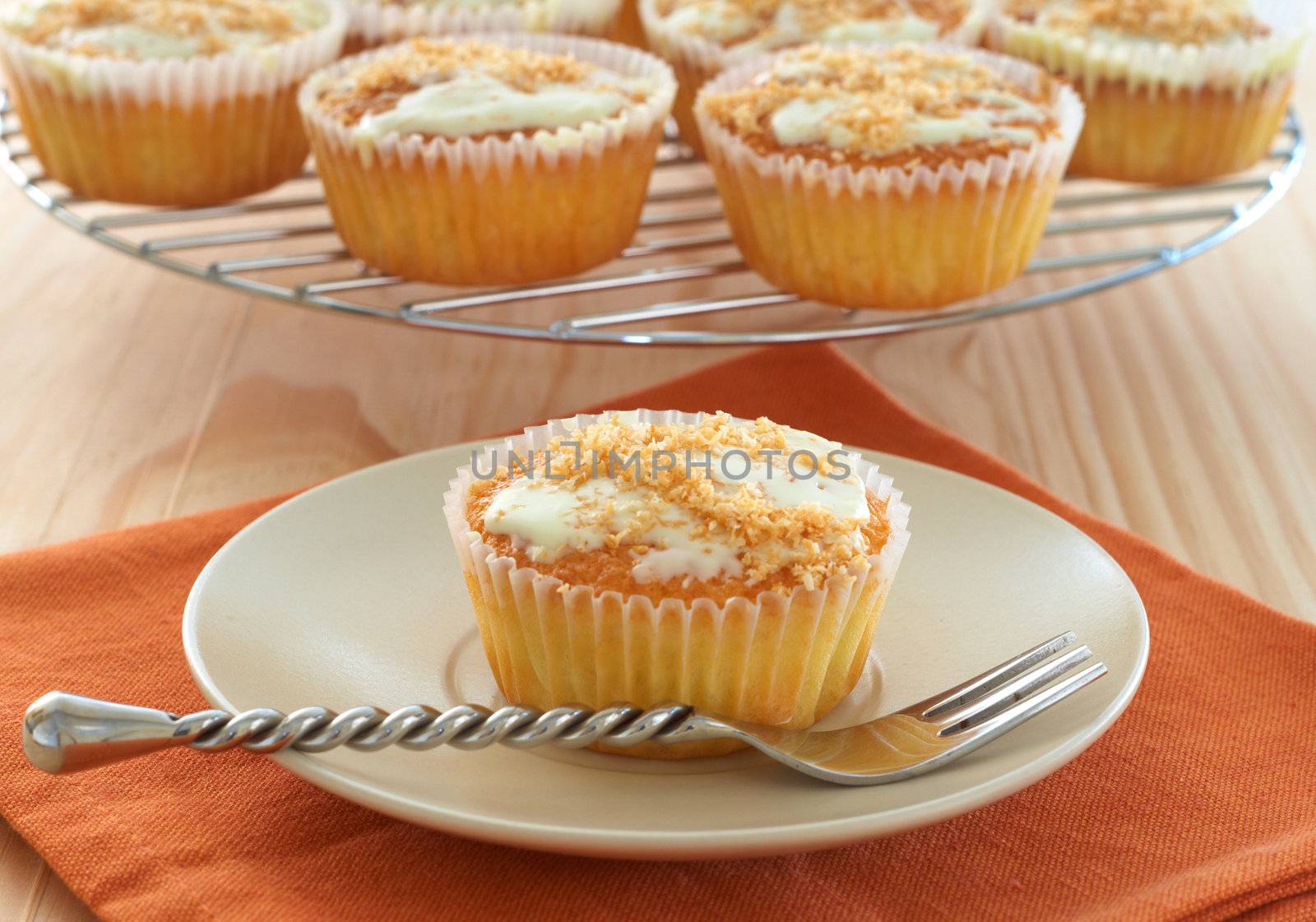 Freshly baked coconut vanilla cupcakes on white plate