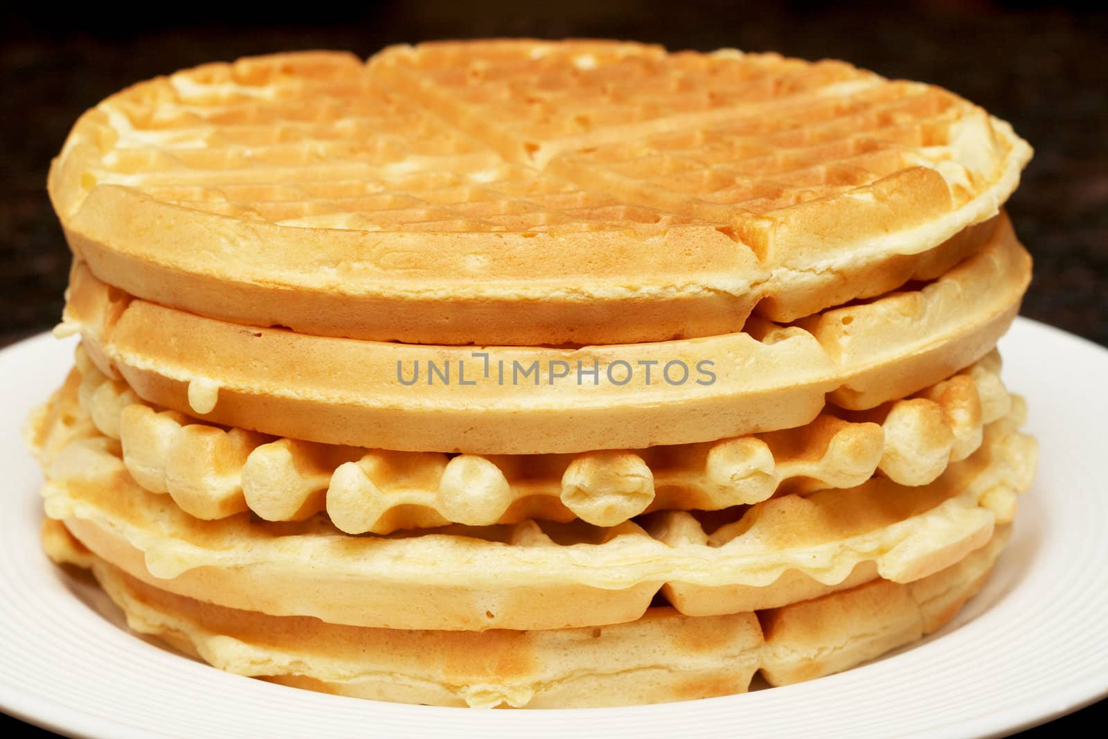 Stack of belgian waffles on white plate