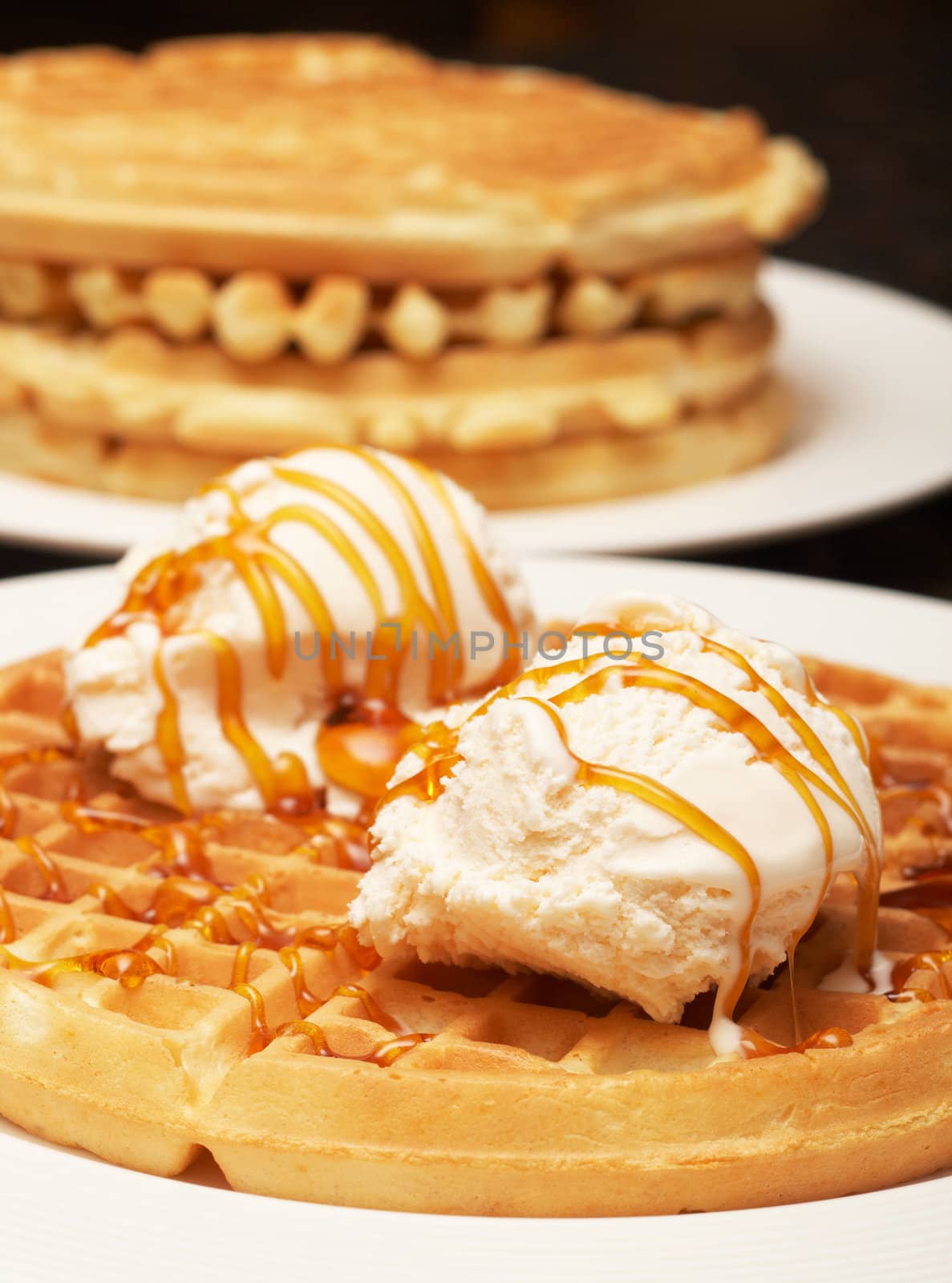 Belgian waffles with ice-cream and syrup on white plate