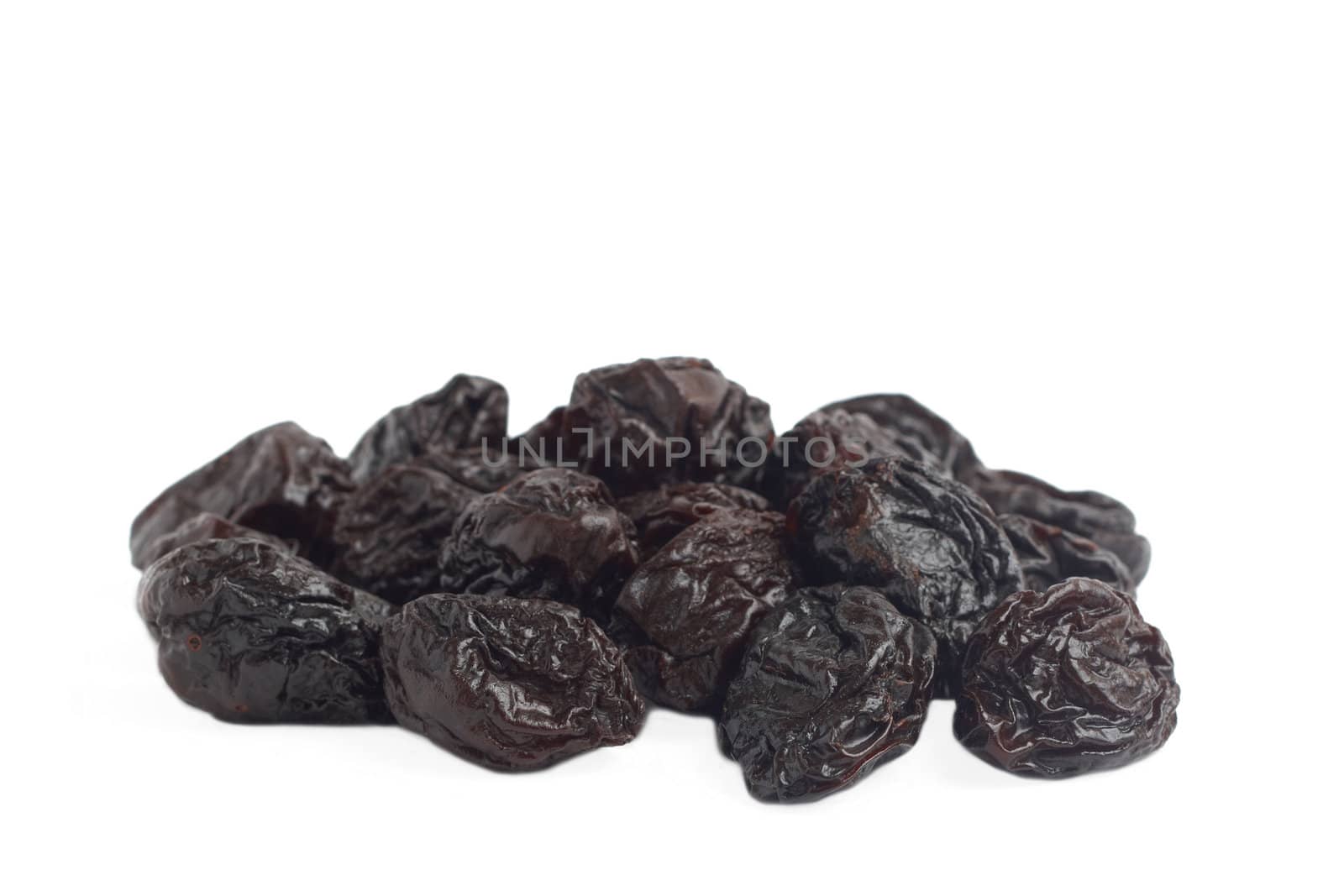 Stack of dried plum prunes on white background