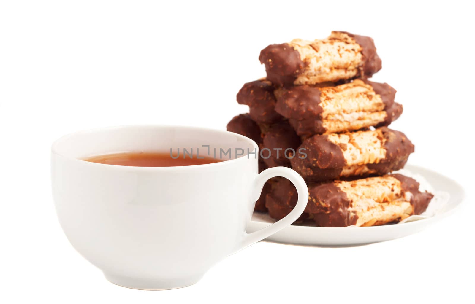 Cup of tea and chocolate dipped meringue cookies on white background