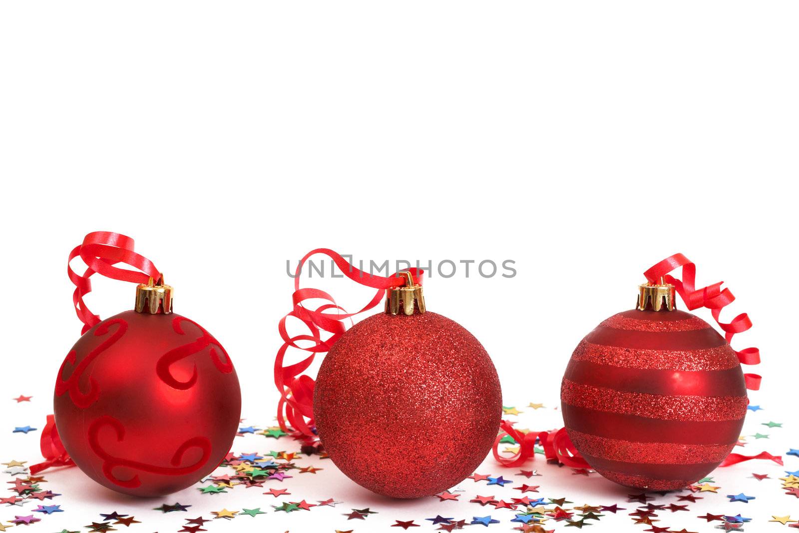 Three red Christmas baubles with colorful stars isolated on white background with copy space. 