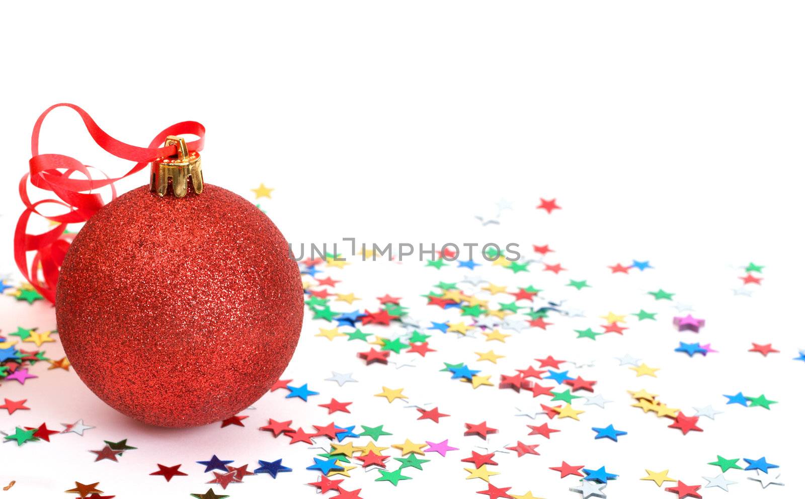 One red Christmas bauble with colorful stars on white background with copy space. 