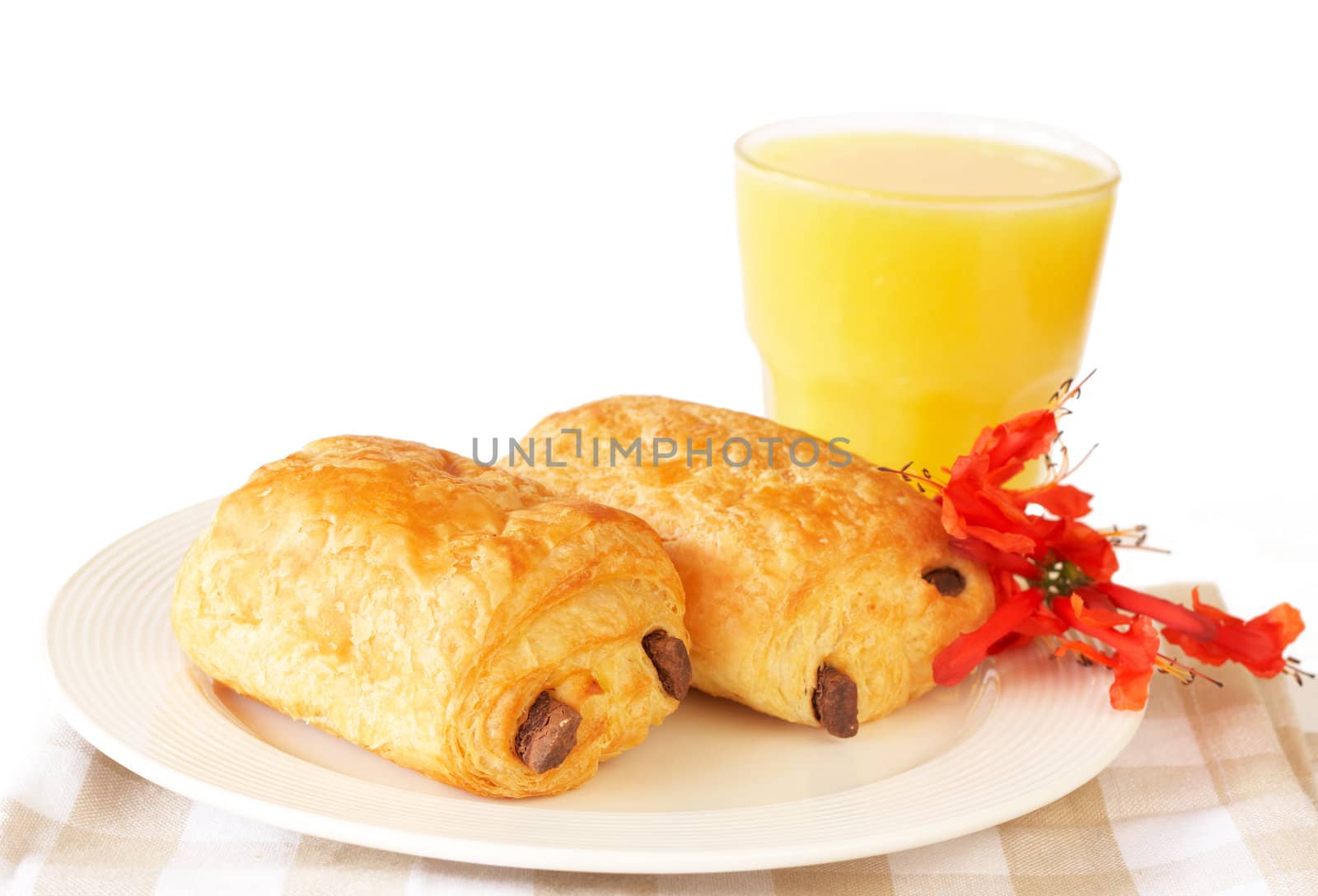 Chocolate croissants and orange juice on white plate