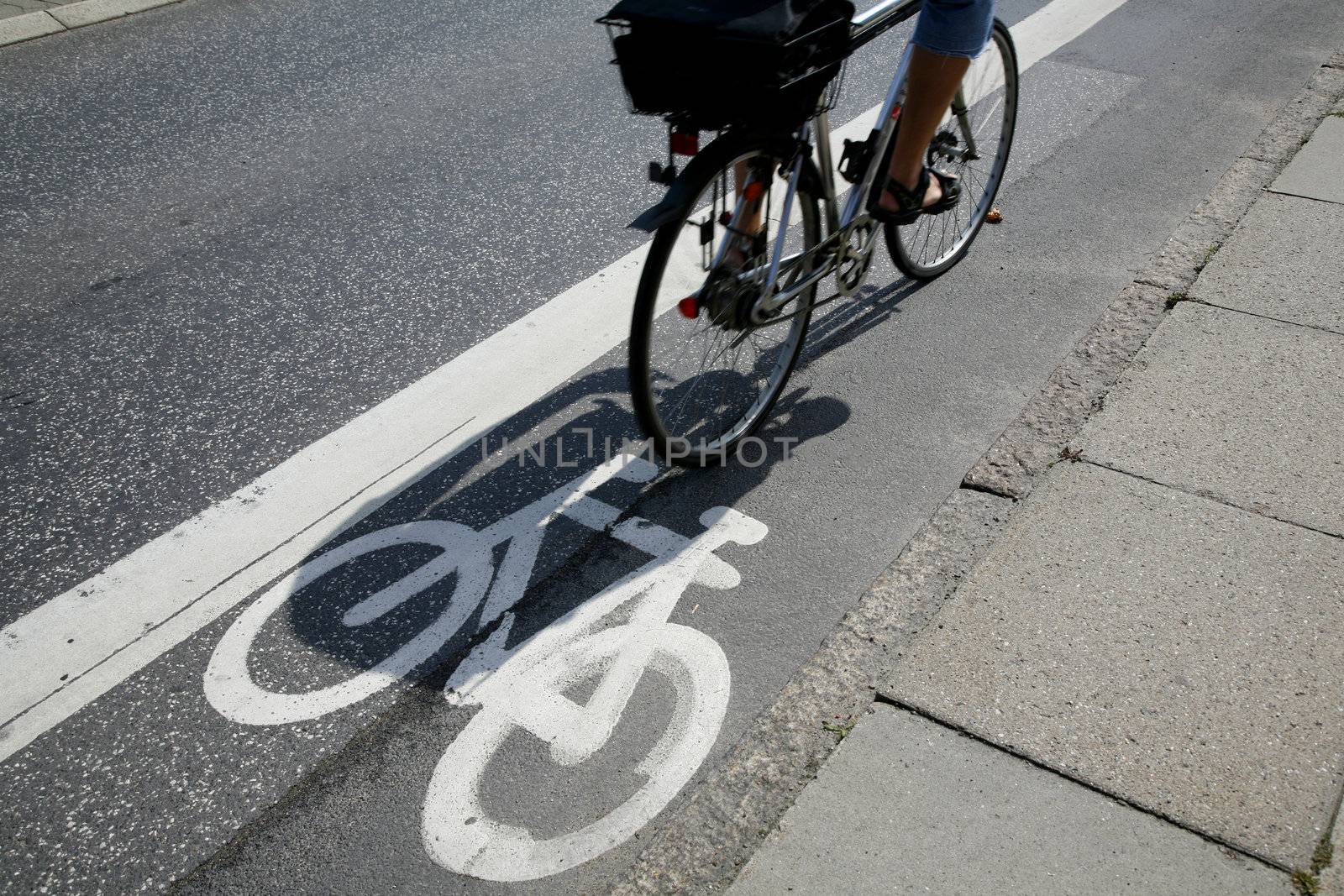 Cyclist passing by on urban cycle path.