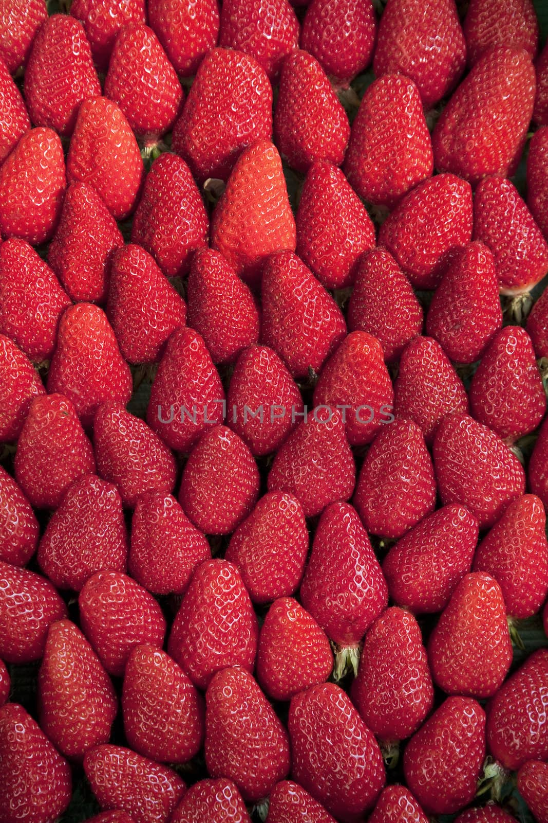 Background of ripe tasty strawberries seen on a Fench market place in April.