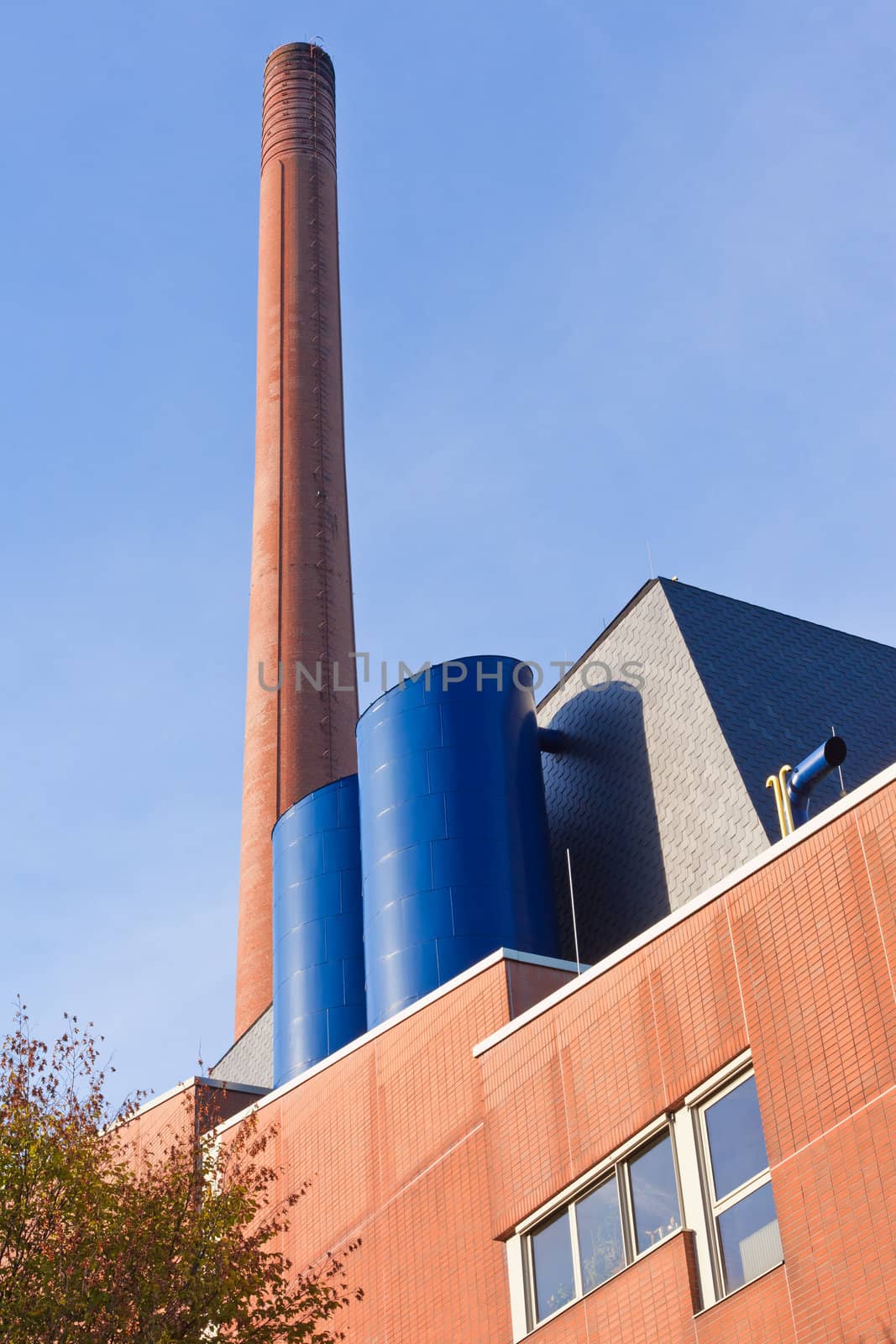 Retro designed industrial brick building with high red brick chimney.