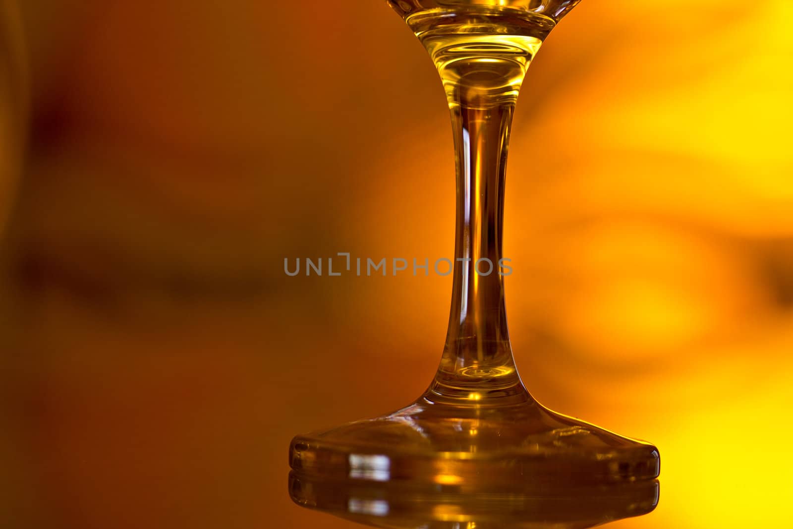 A closeup shot of the base of a wine glass on a moody background