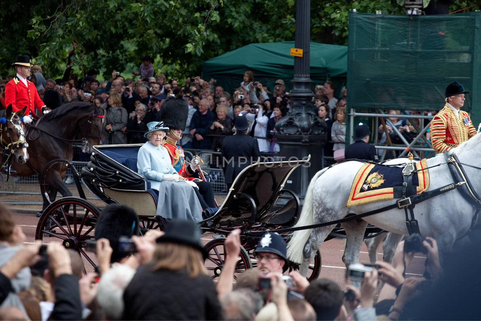 LONDON - JUNE 11: The Queen Elizabeth II and The Duke of Edinburgh leaves Trooping the Color ceremony trough streets crowded of spectators in London, England on June 11, 2011. Ceremony is performed by regiments on the occasion of the Queen's Official Birthday