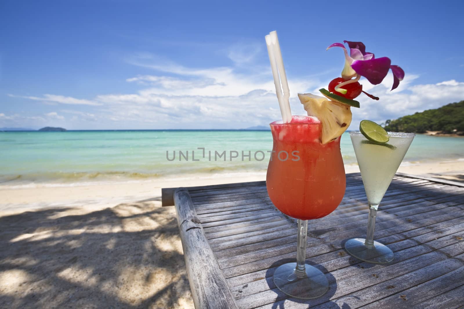 Couple of cocktails with a beautiful beach in the background.