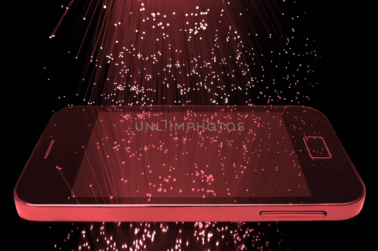 Many illuminated red fiber optic light strands cascading down against a black background and reflecting on the screen of a smart phone in the foreground