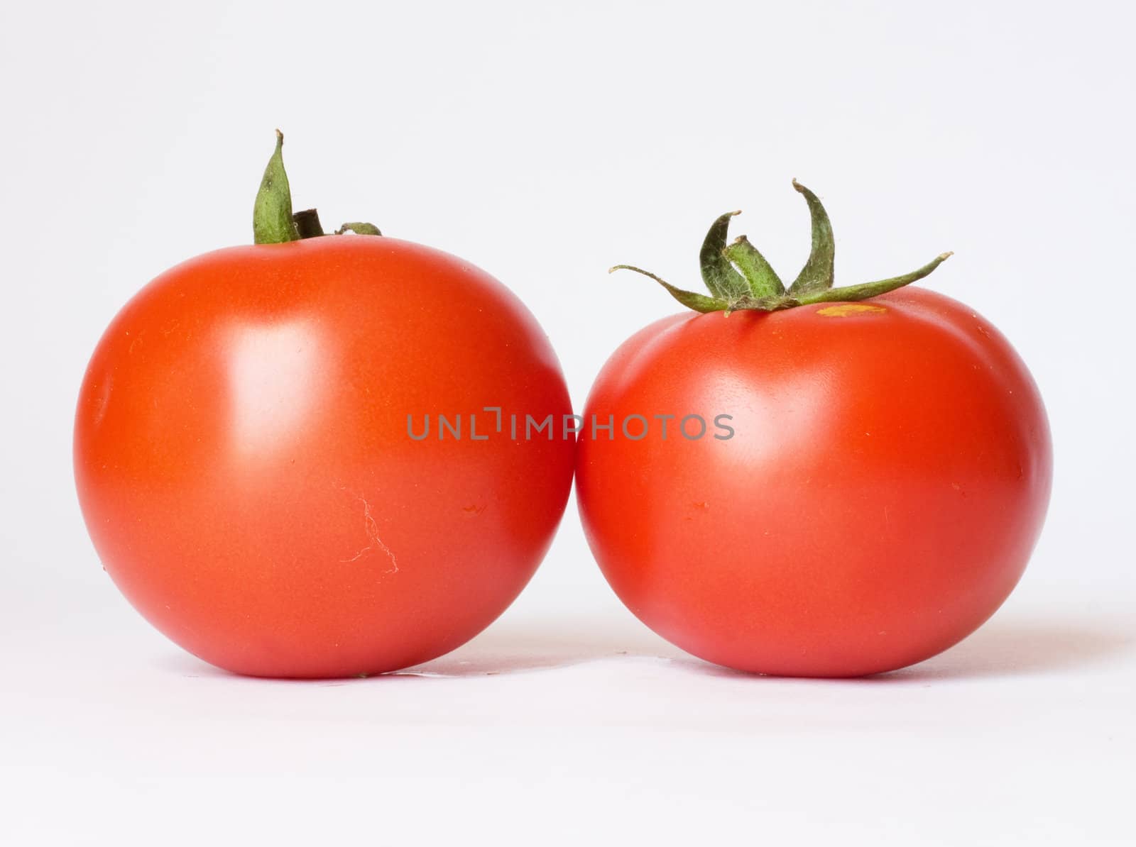 Two tomatoes isolated on white background 