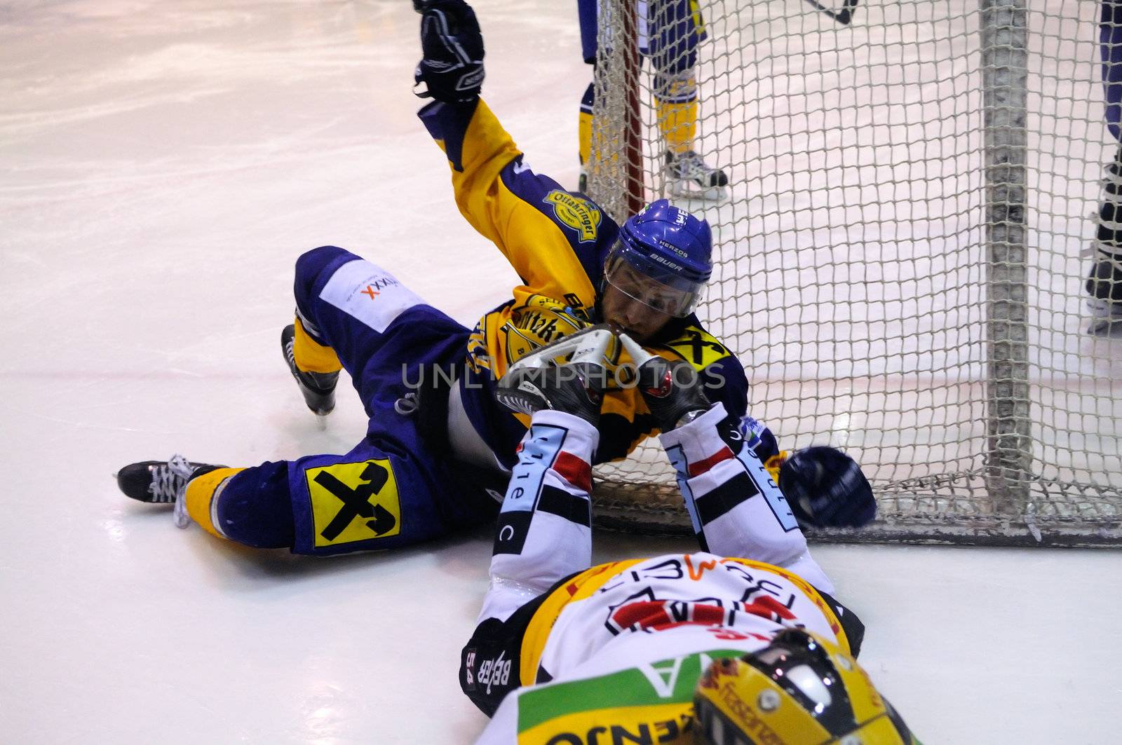 ZELL AM SEE, AUSTRIA - FEB 22: Austrian National League. Stefan Uhl gets caught by the skates of VEU player. Game EK Zell am See vs. VEU Feldkirch (Result 3-1) on February 22, 2011 at hockey rink of Zell am See