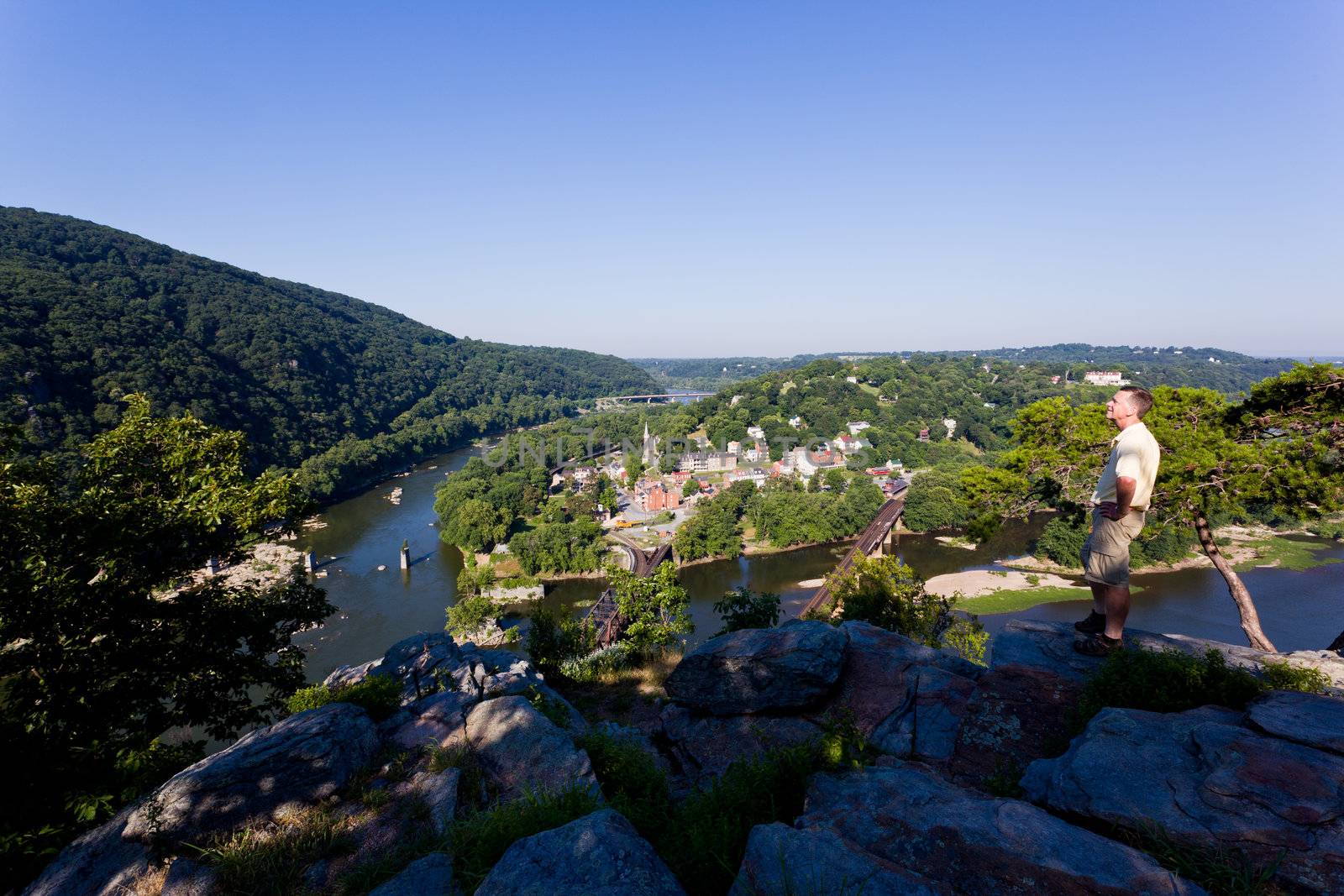 Senior male hiker overlooking the shenandoah and potomac rivers by the town of Harpers Ferry