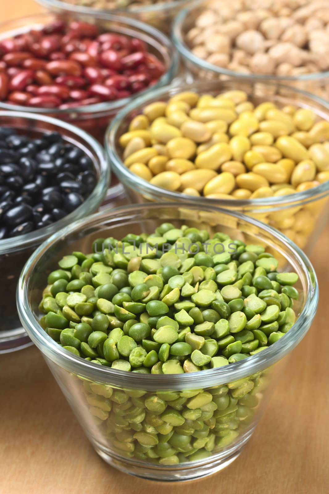 Split peas and other legumes (black beans, canary beans, kidney beans, chickpeas) in glass bowls (Selective Focus, Focus one third into the split peas) 