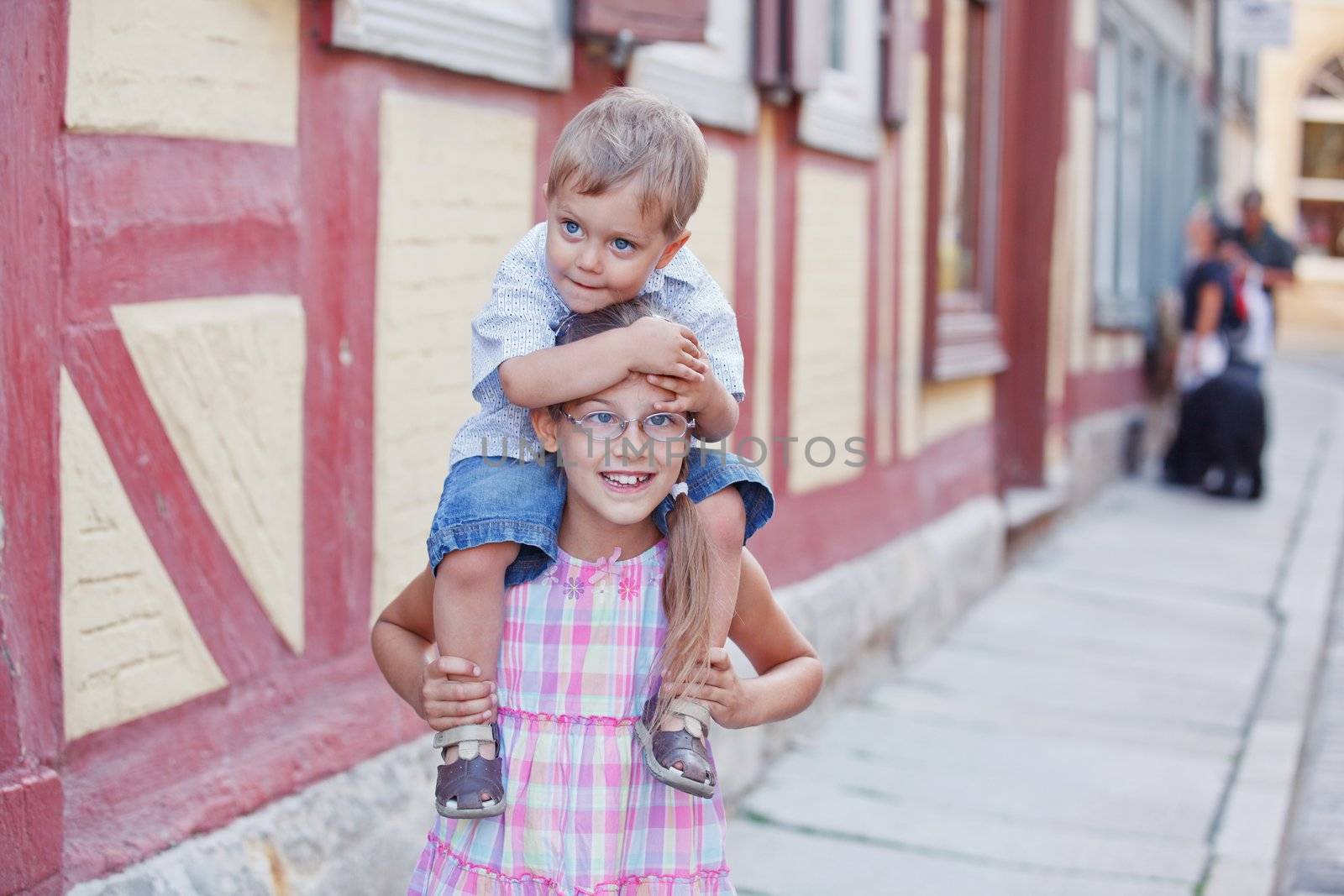 Brother and sister outdoors in city on beautiful summer day