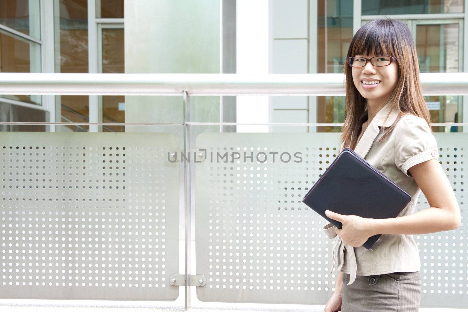 Education / Business woman passing by office building