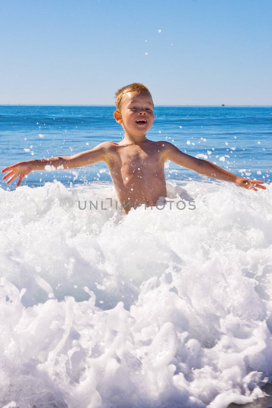 A young child playing in the sea