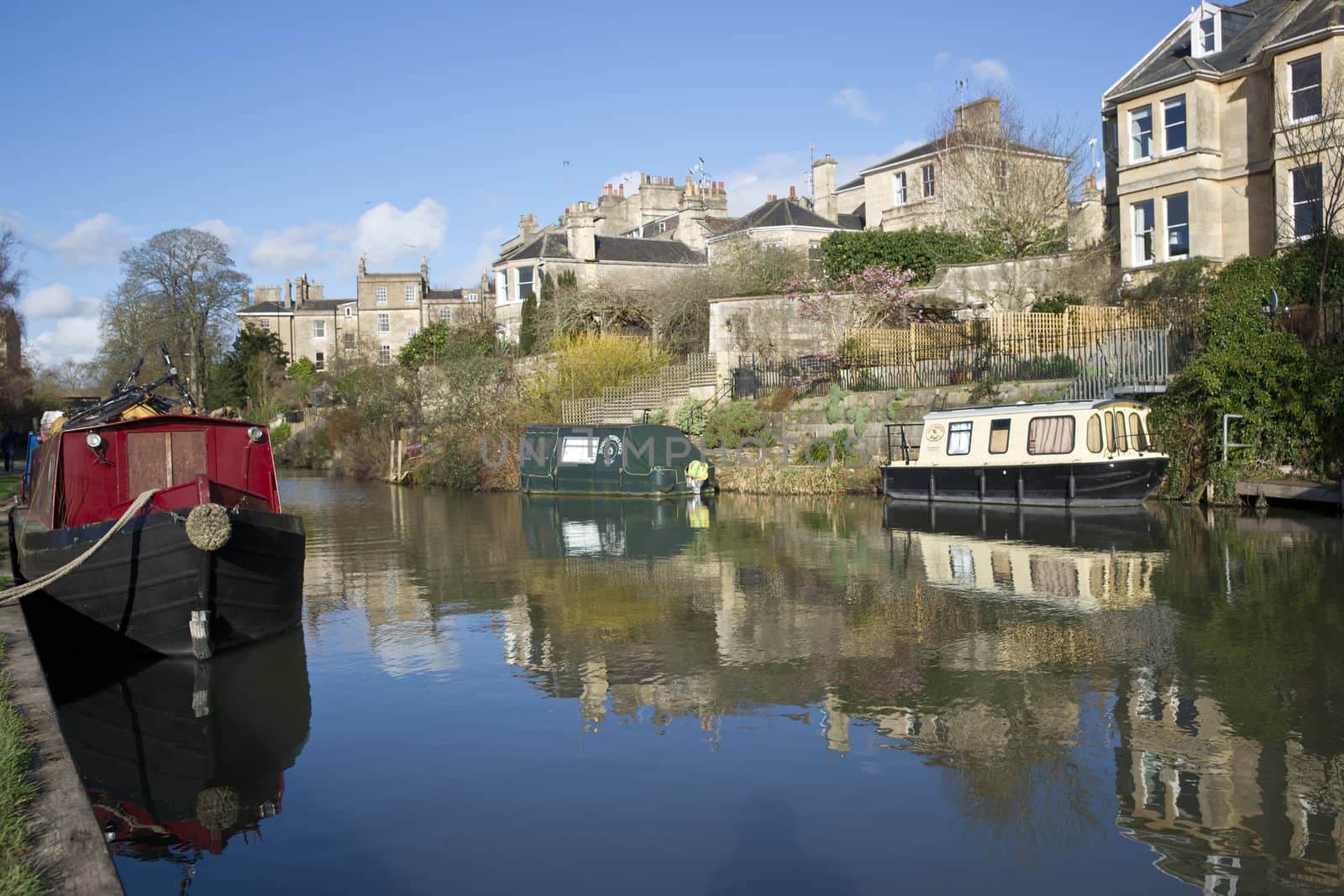 Boats line the banks of the Kennet and Avon Canal running through the historic city of Bath in Somerset, England