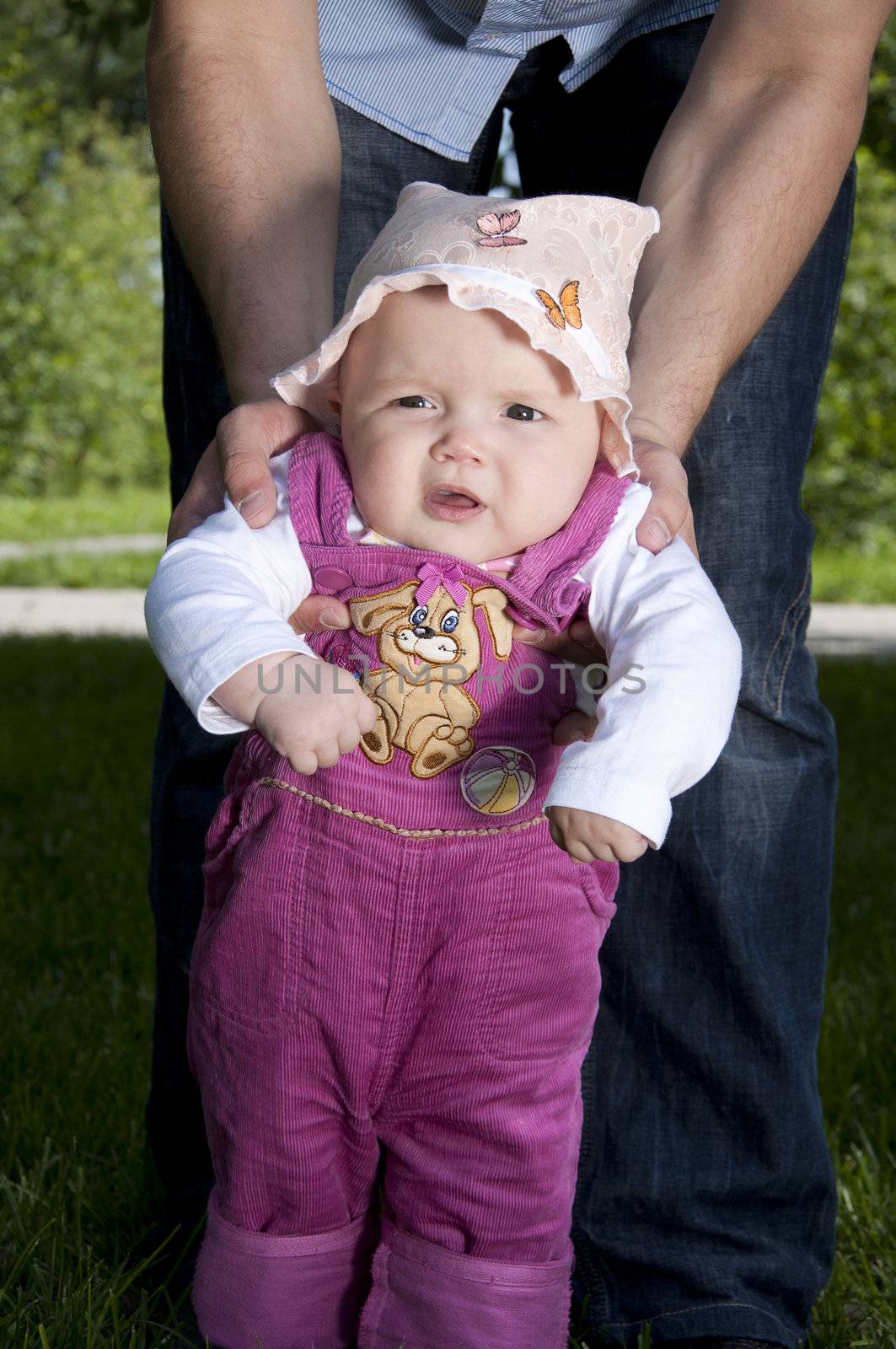 father playing with baby, raised it high above them, against the background of blue sky