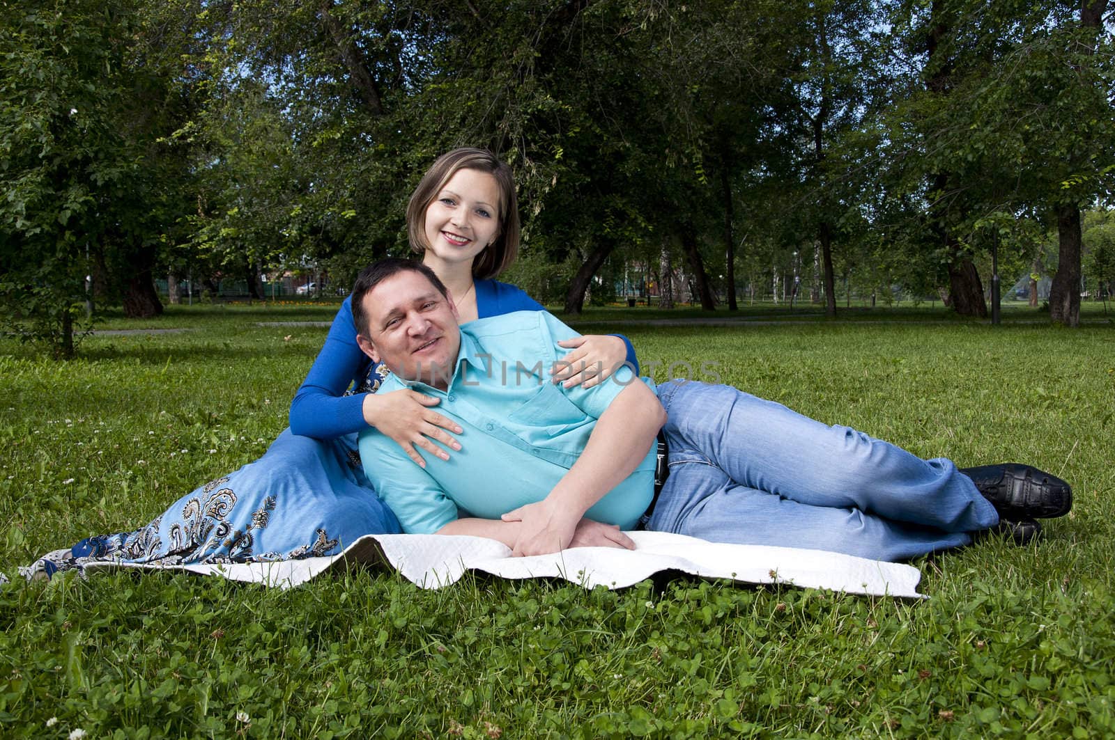 man and the woman lay together on a coverlet