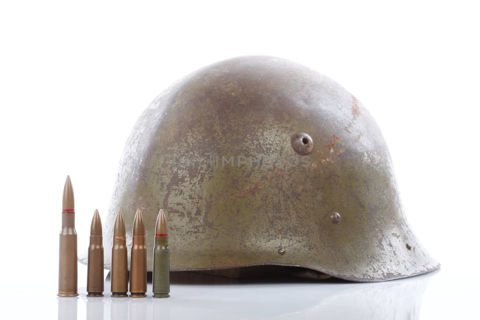 Old military helmet and cartridges over white