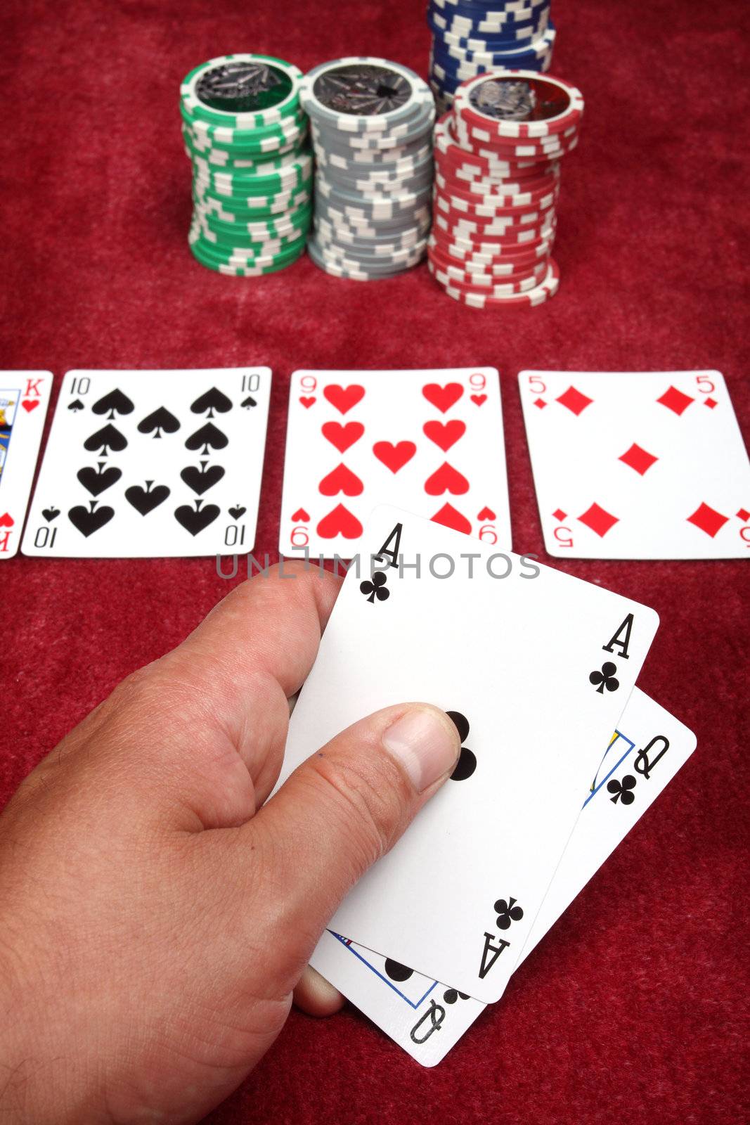 Man hand holding two cards in a game of poker