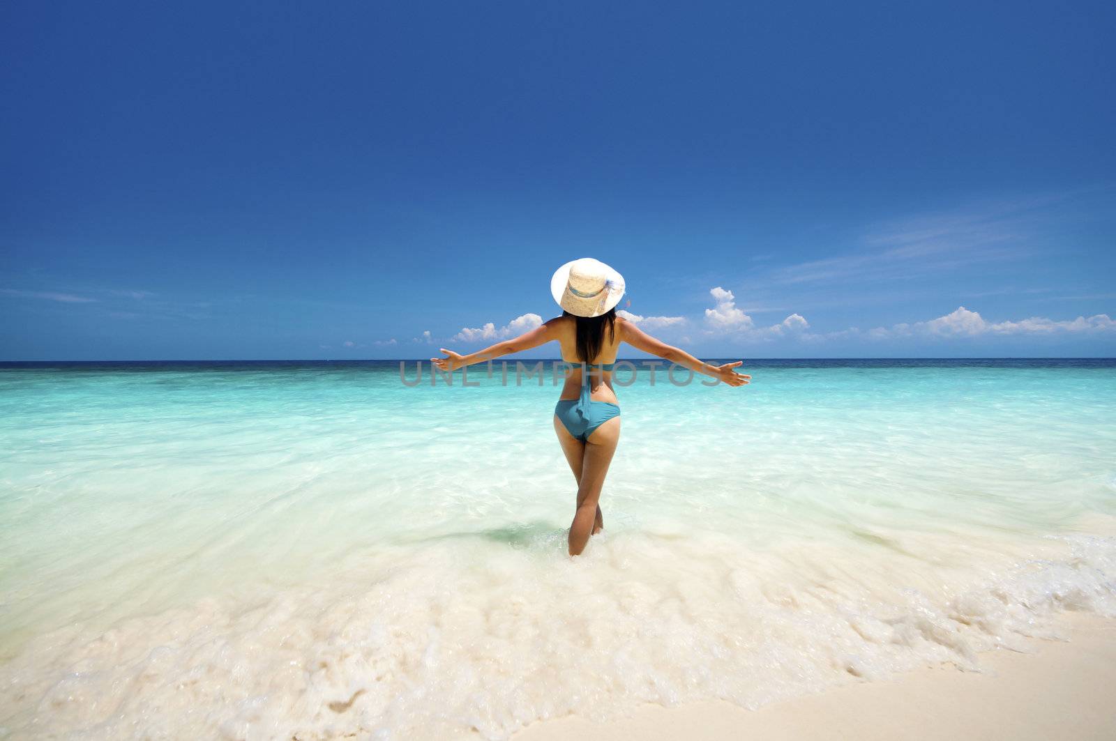 Young woman arms out enjoying the fresh air at beach