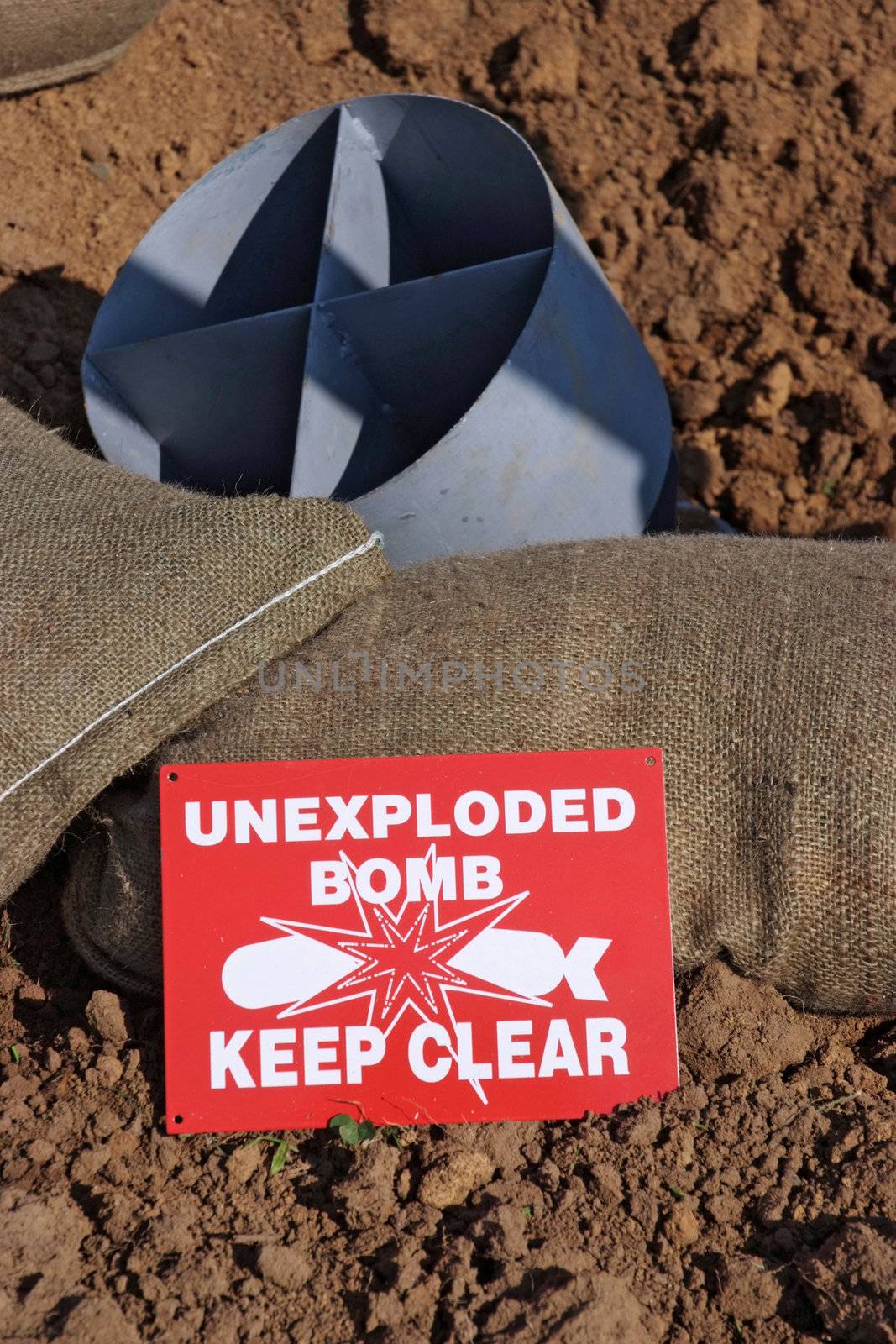 Mock unexploded bomb and sign from the Second World War, with sand bags