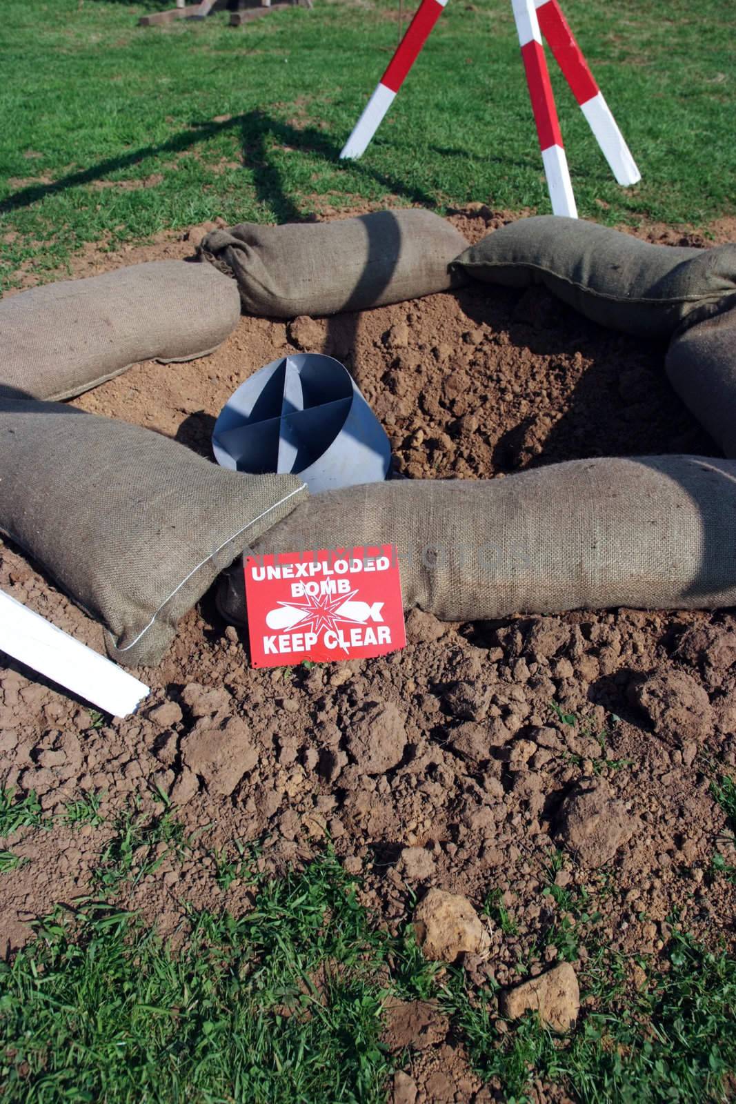 A mock Second World War bomb in crater with warning signs