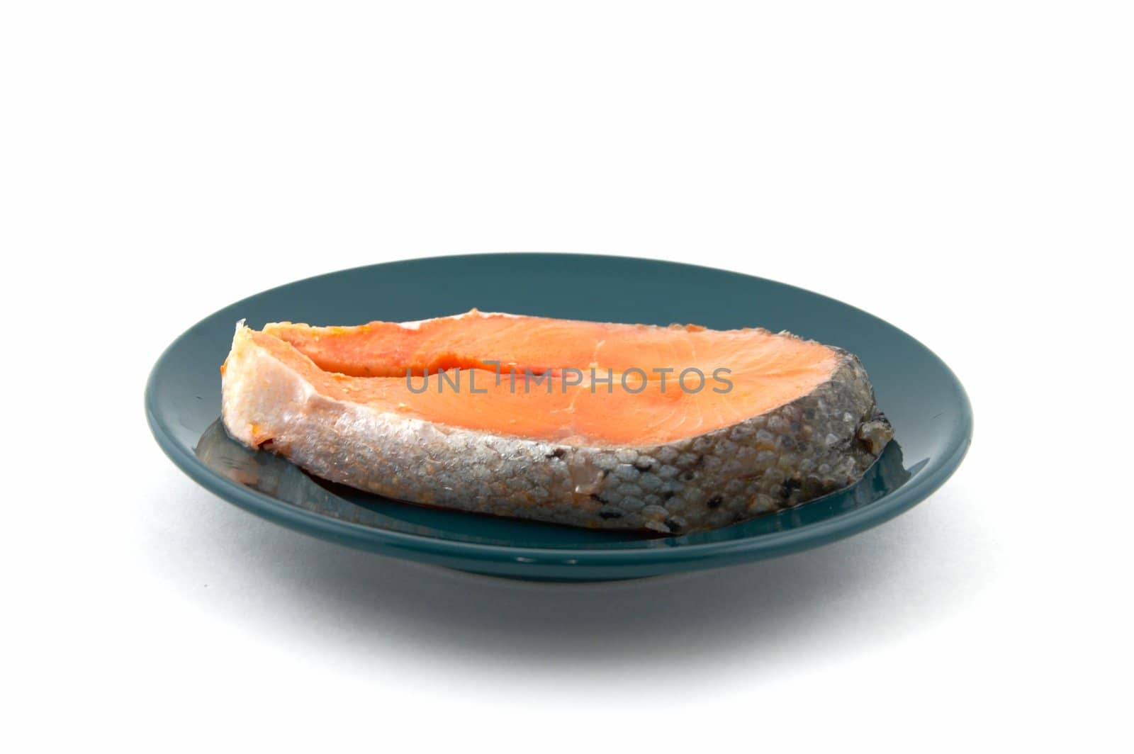 Fresh uncooked Pacific Coast Salmon on a plate of green color. 
It is not isolated, and it is photographed on a white background.