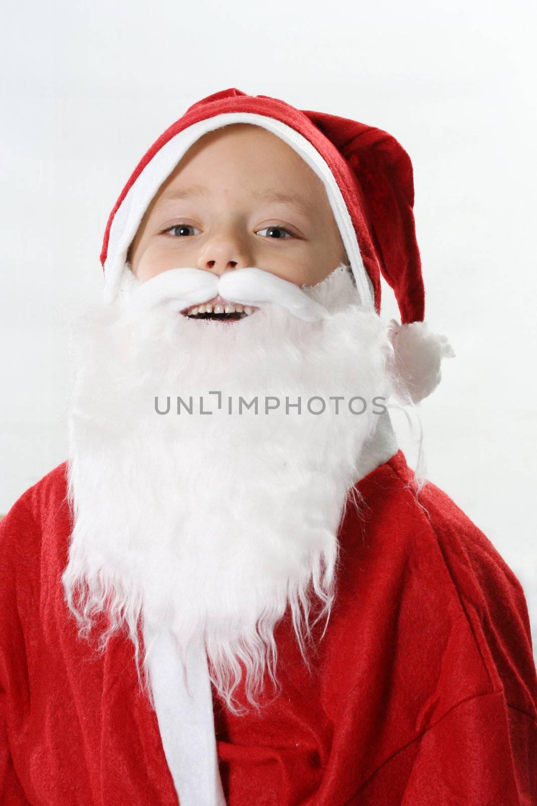 Portrait of a smiling boy in cap Santa in a white beard