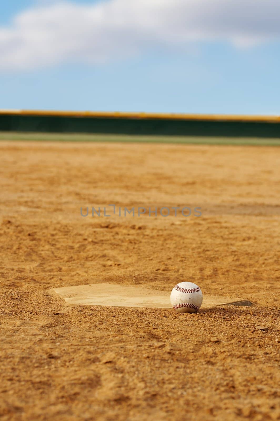 one baseball on home plate at a sports field