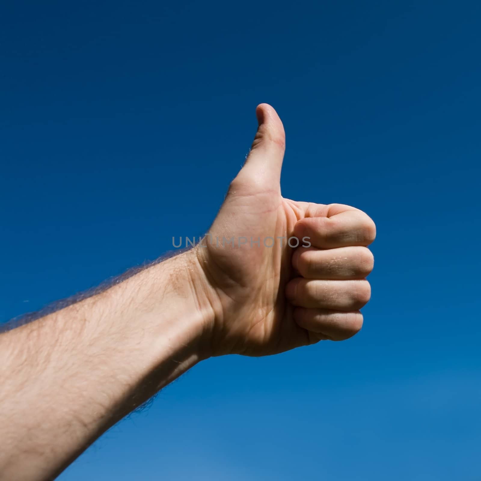 raising thumb up with blue sky at background