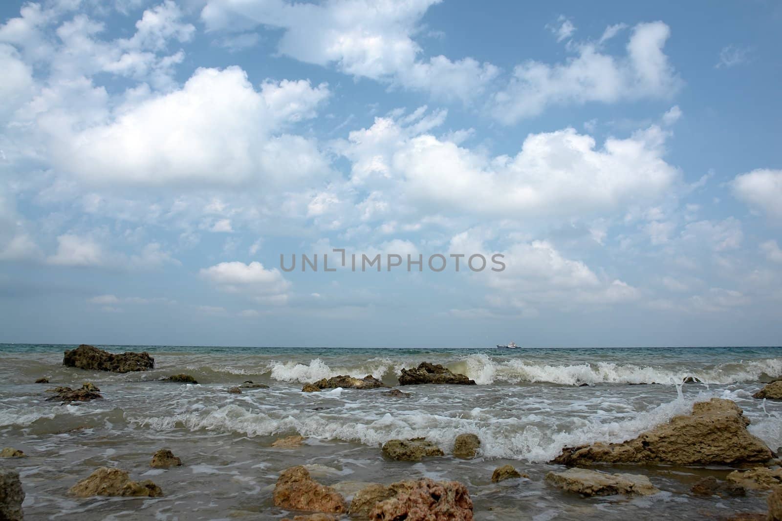 a stony seashore with cloud sky at background		