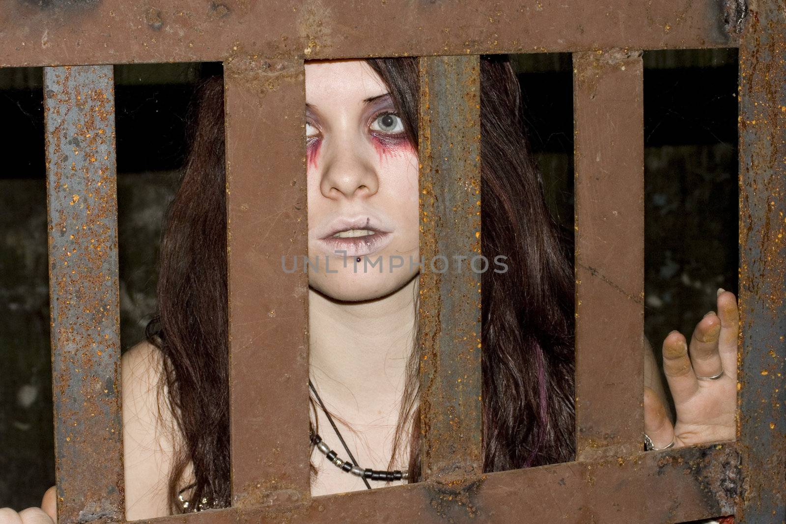 The attractive girl the vampire behind an iron lattice