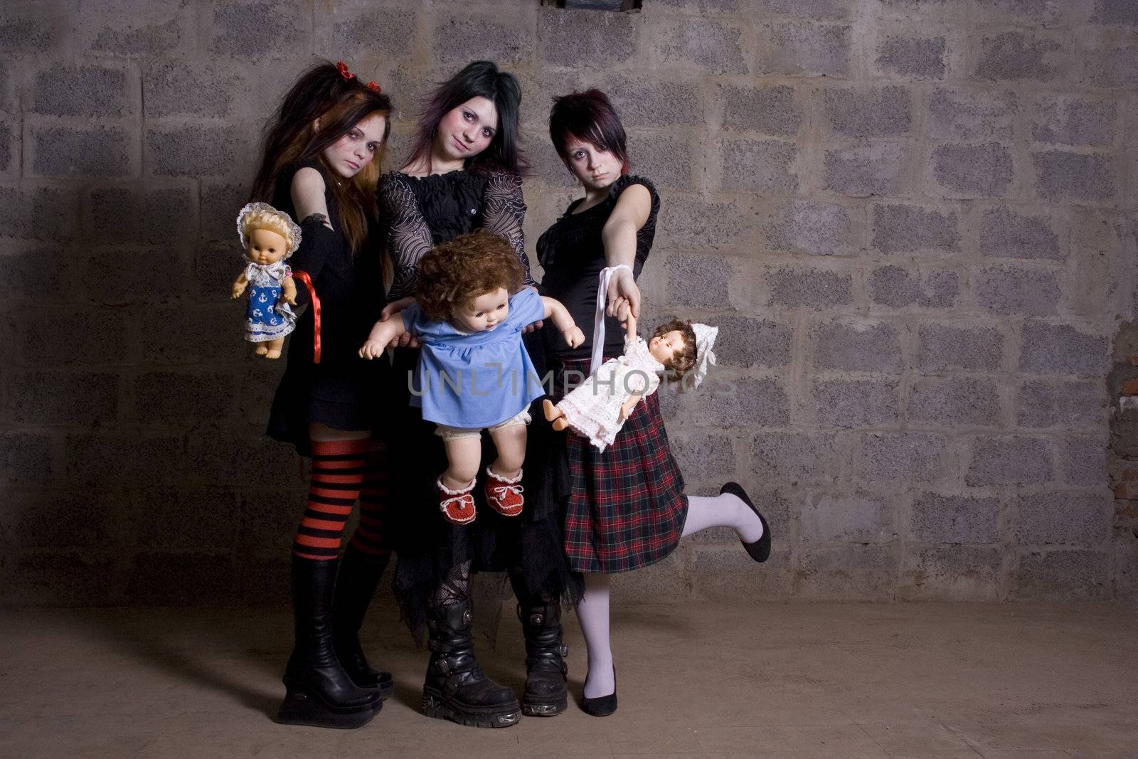 Sad, gloomy girls hold in hands of dolls