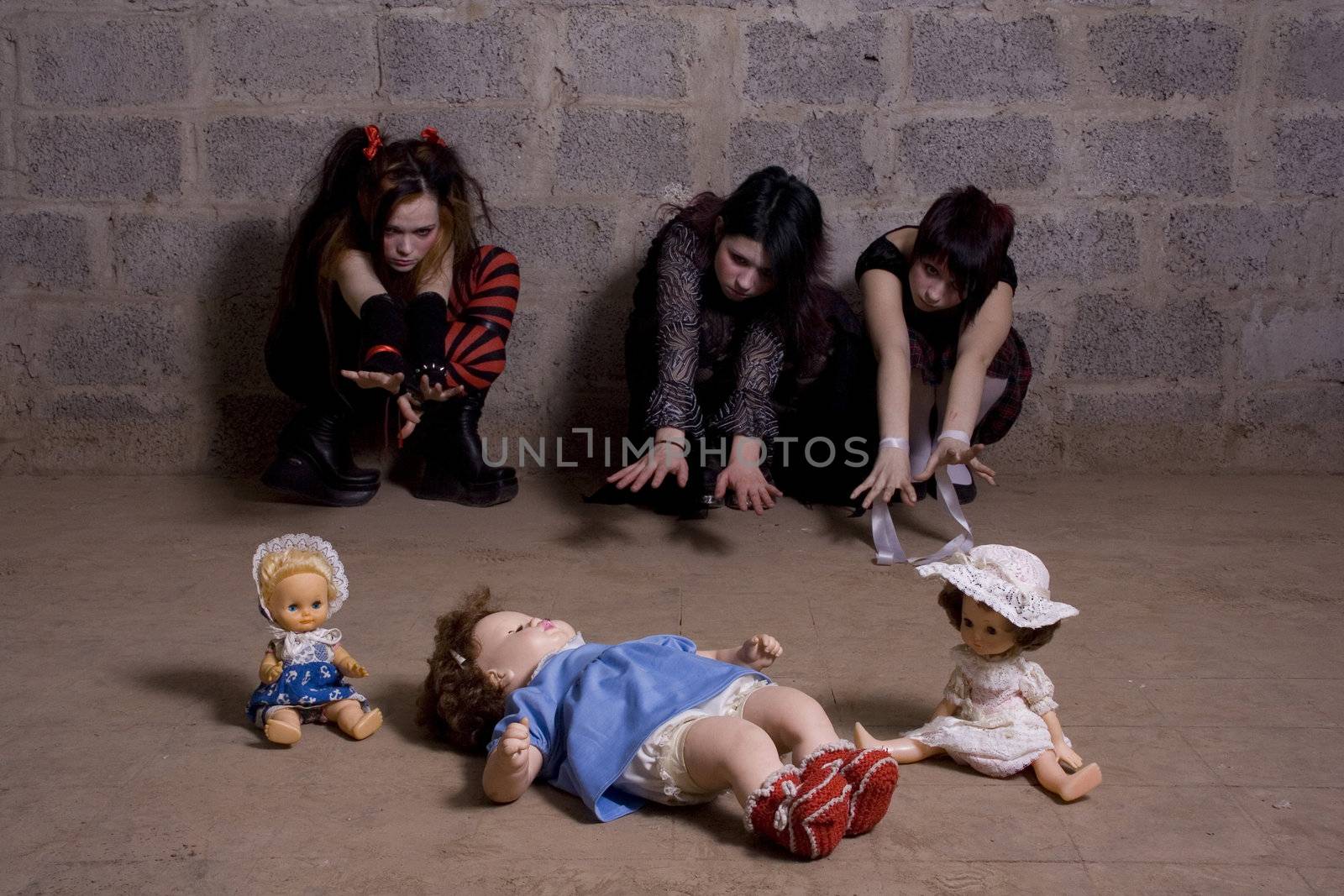 Sad, gloomy girls pull hands to dolls