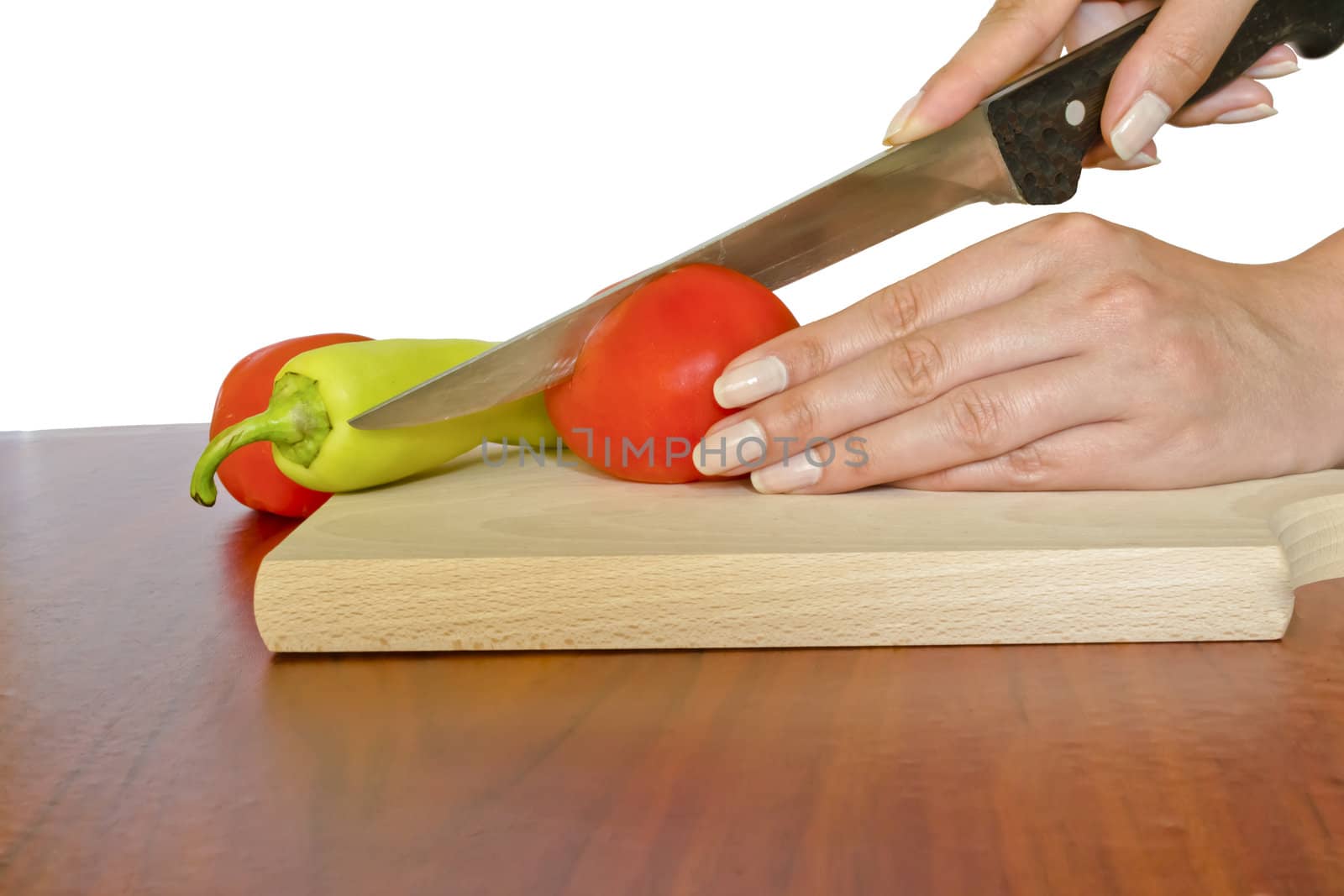 Cutting tomato on wooden board by vician