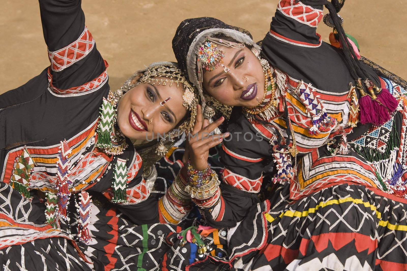 Beautiful Kalbelia dancers in ornate black costumes trimmed with beads and sequins at the annual Sarujkund Fair near Delhi, India.