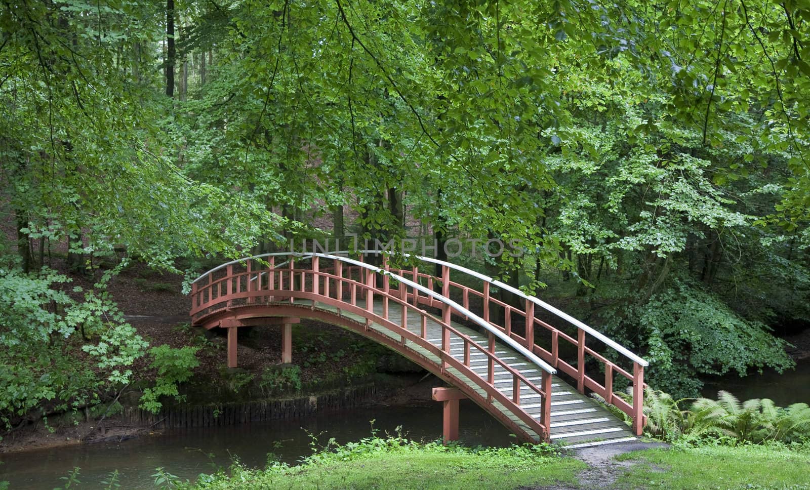 Nice old  Danish wooden bridge in park at summertime.