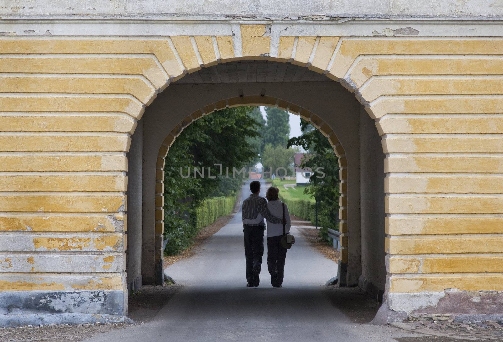 Young couple leaving Valdemar Castle, Denmark through one of the gates.