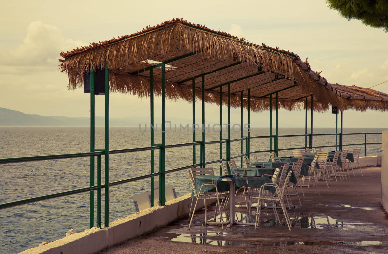 Beach cafe by the Adriatic Sea after rain - Croatia. Image is cross processed and a little film grain added to reflect age.