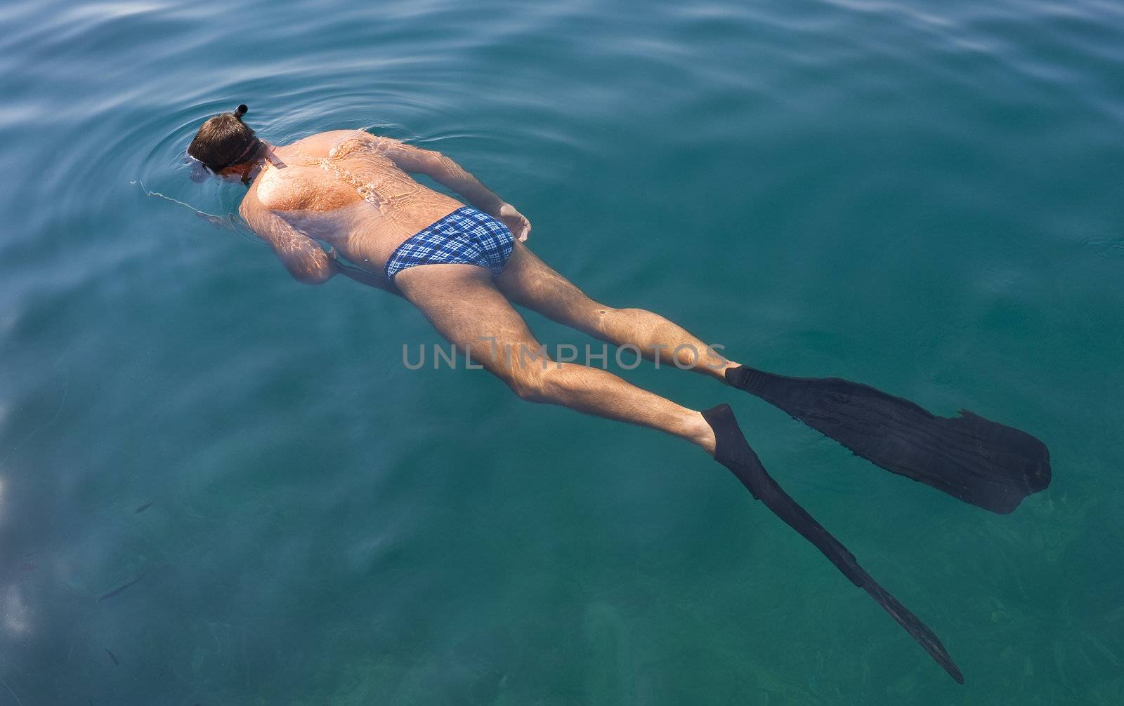 Young man snorkeling after fish in the Adriatic Sea, Croatia.