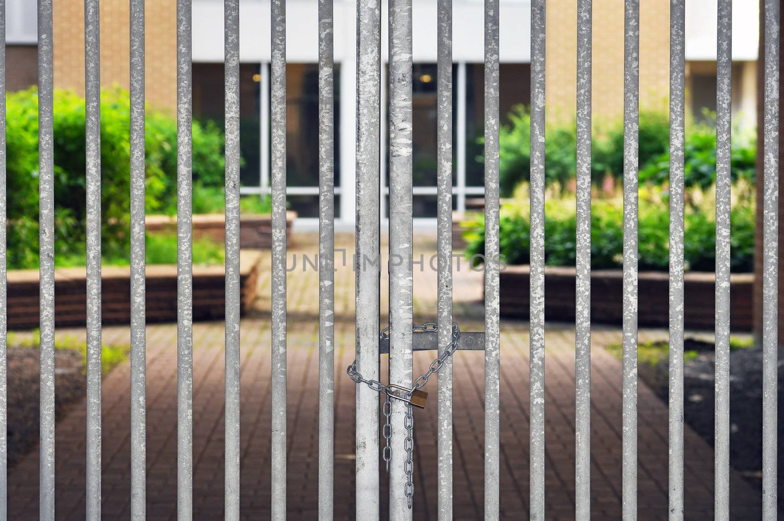 Gated residential community, locked fence with padlock and chain restricting access to luxury condos.