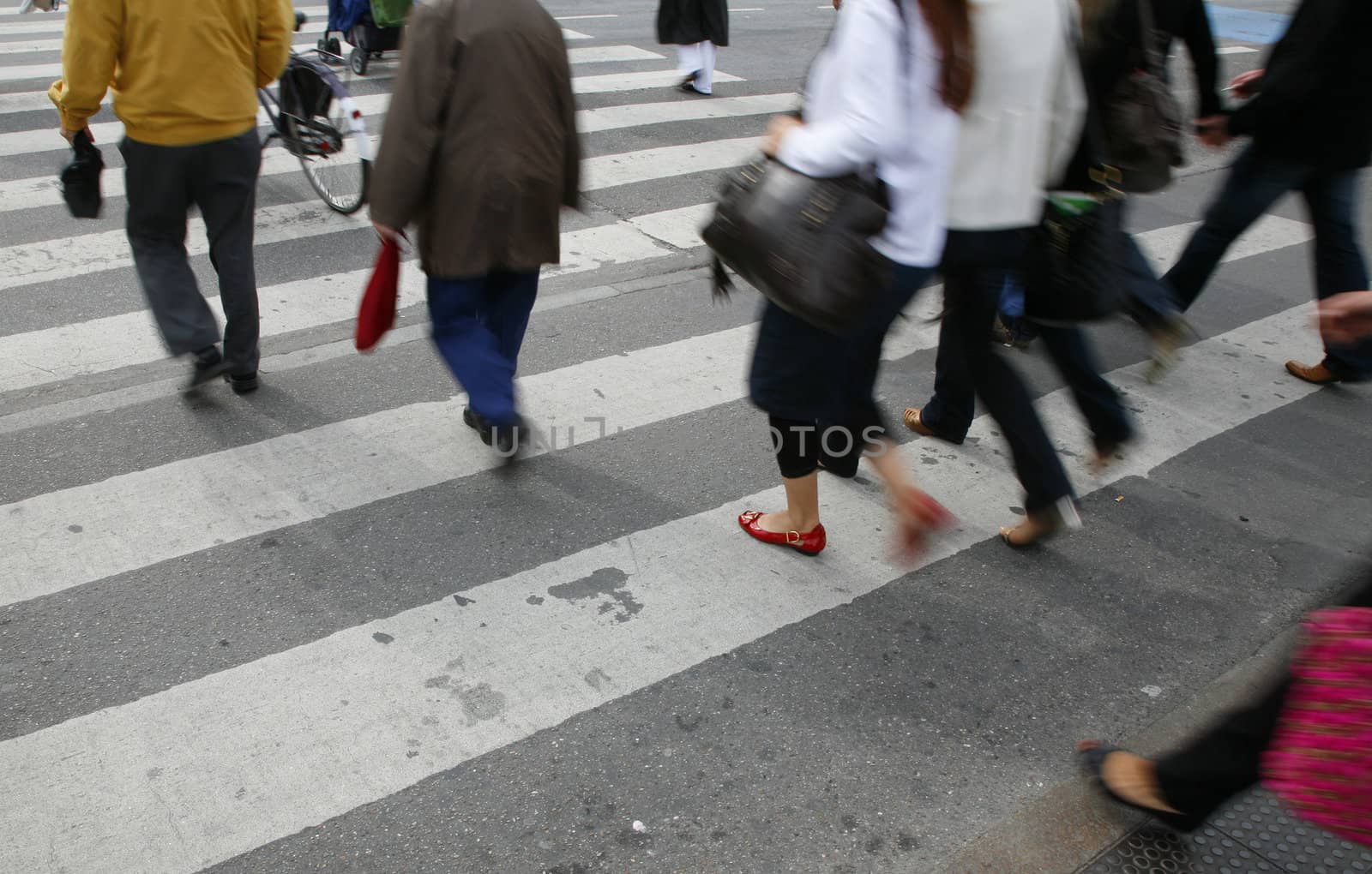 Rush hour in an urban  zebra crossing. Focus on red shoe. With place for text.