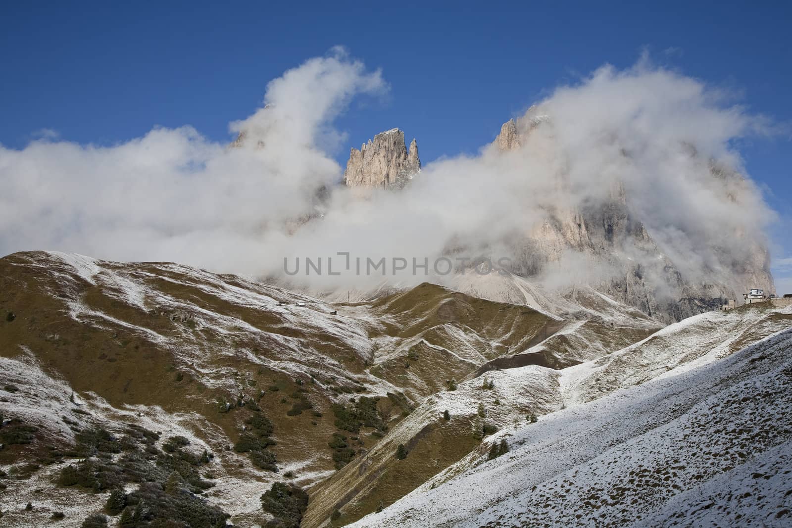 September morning with low hanging clouds and the first snow in Passo di Sella, Italy.