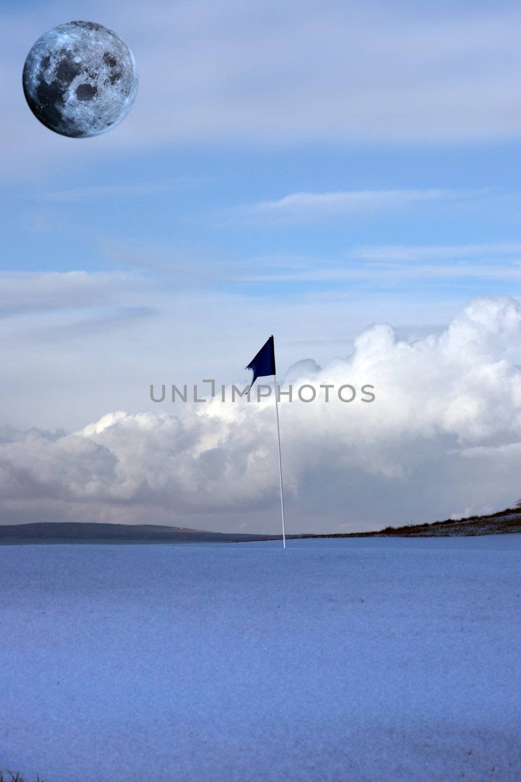 a snow covered links golf hole in ireland with blue flag and full moon in sky