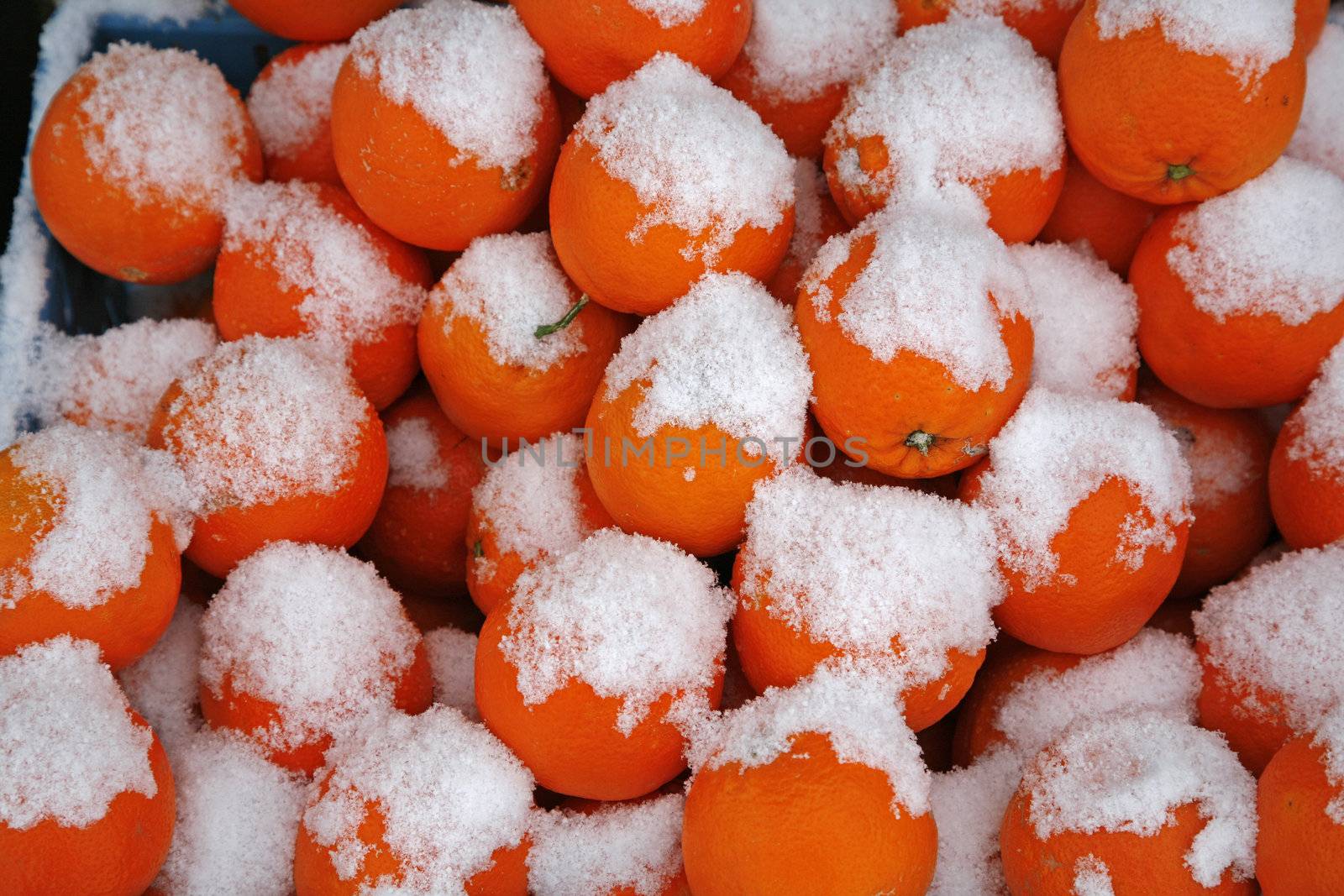 A box of oranges seen at a marketplace a cold winterday.
