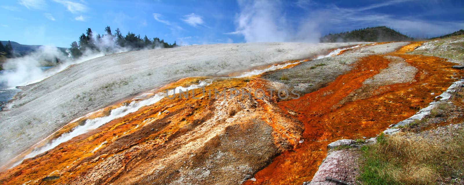 Hot water from the Midway Geyser Basin cascades into the Firehole River in Yellowstone National Park - Wyoming.